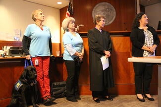 On August 25, Nemo, the young black Labrador Retriever, was sworn in as a courthouse dog. He is pictued with his two CASA handlers, Judge Nancy Davis and SFCASA Executive Director, Renee Espinoza.