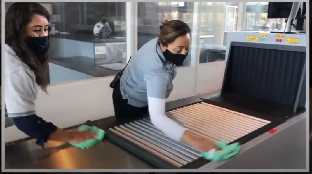two femail staff wiping scanning equipment and wearing masks