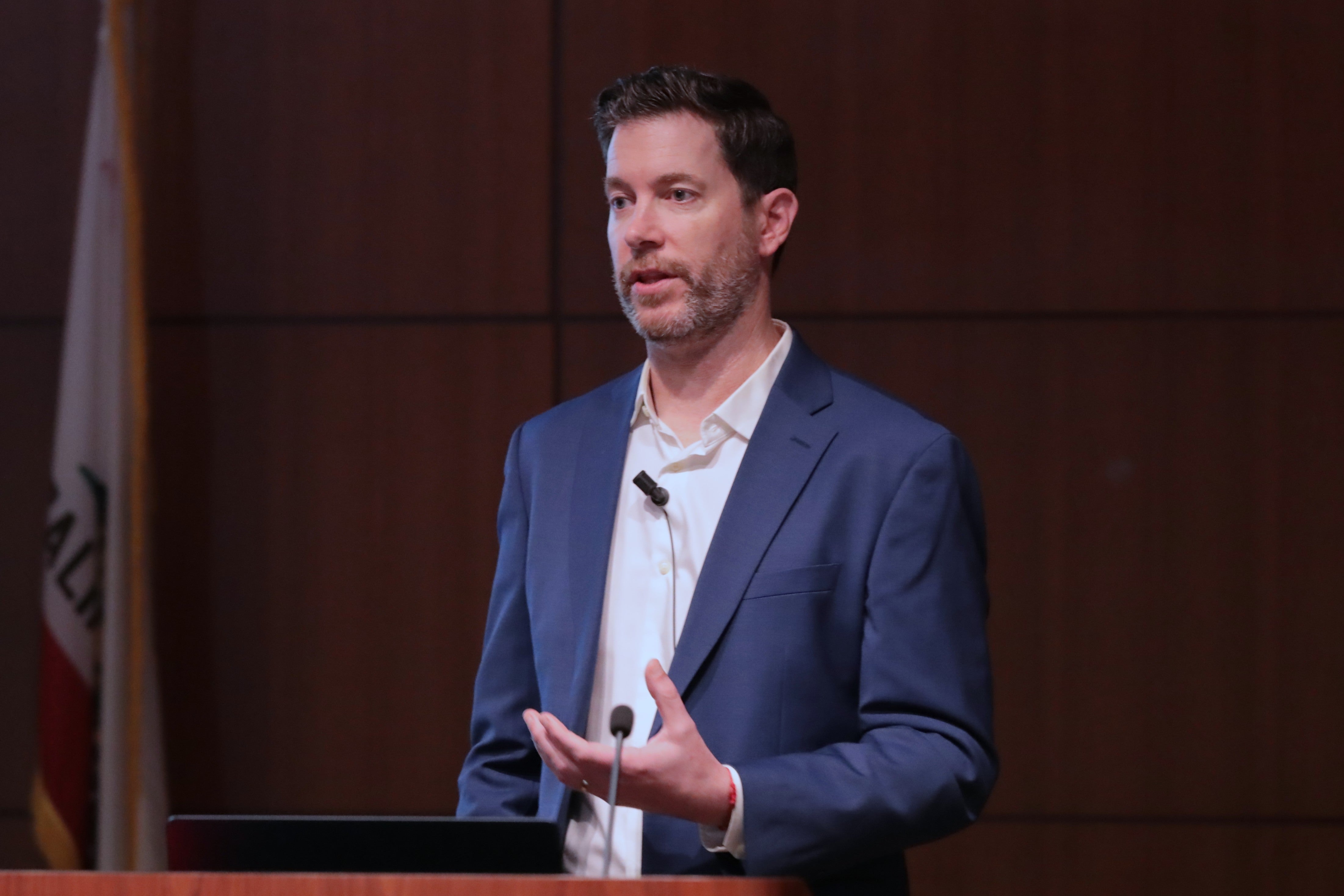 Adam Dodge speaking to audience wearing a blue blazer.