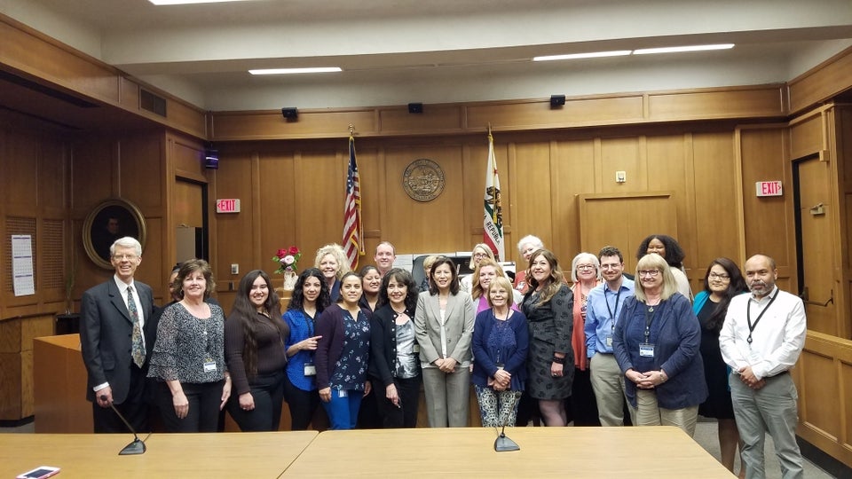Chief Justice Tani G. Cantil-Sakauye (center) meets court staff from the Superior Court of Monterey County. Staff of the monterey court stand in the courtroom with the chief justice