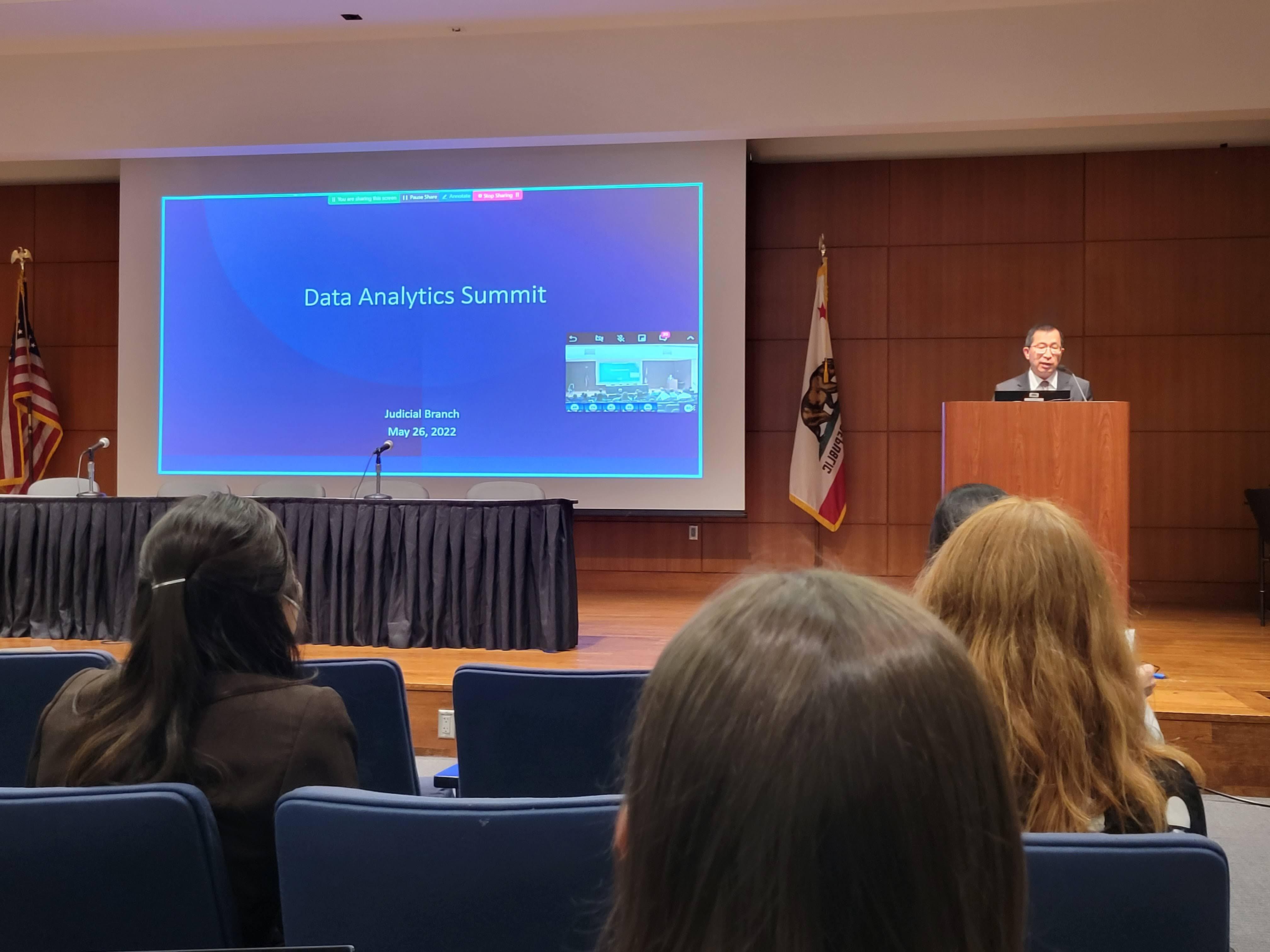Man standing behind a podium on stage in auditorium