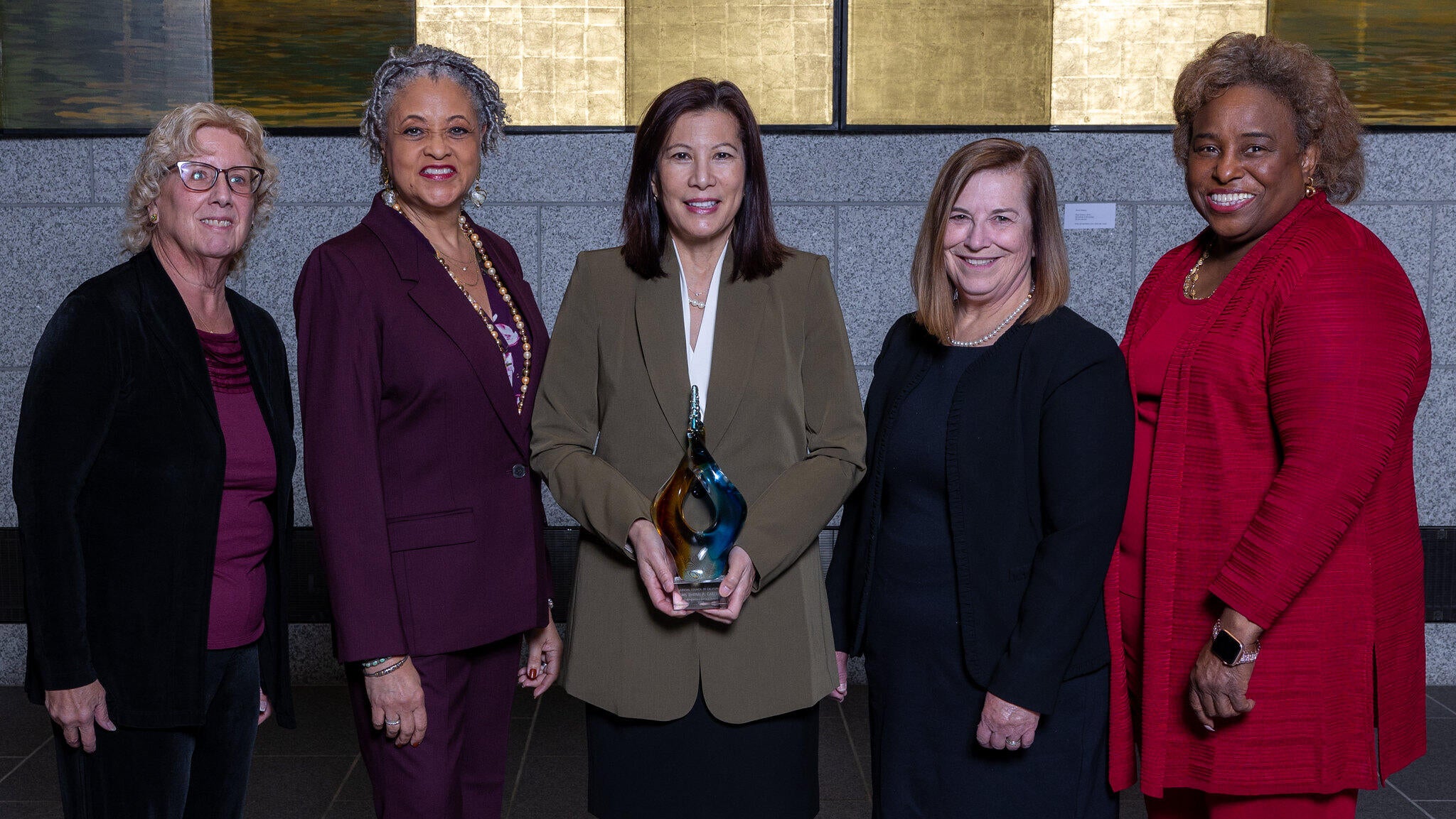 five women standing with Chief Justice cetner holding a DSA  