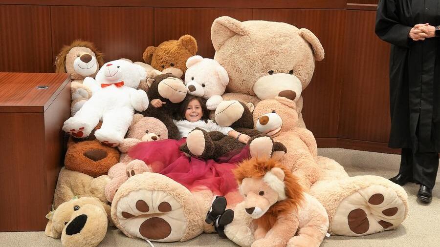 inside courtroom pile of stuffed bear surrounding a child