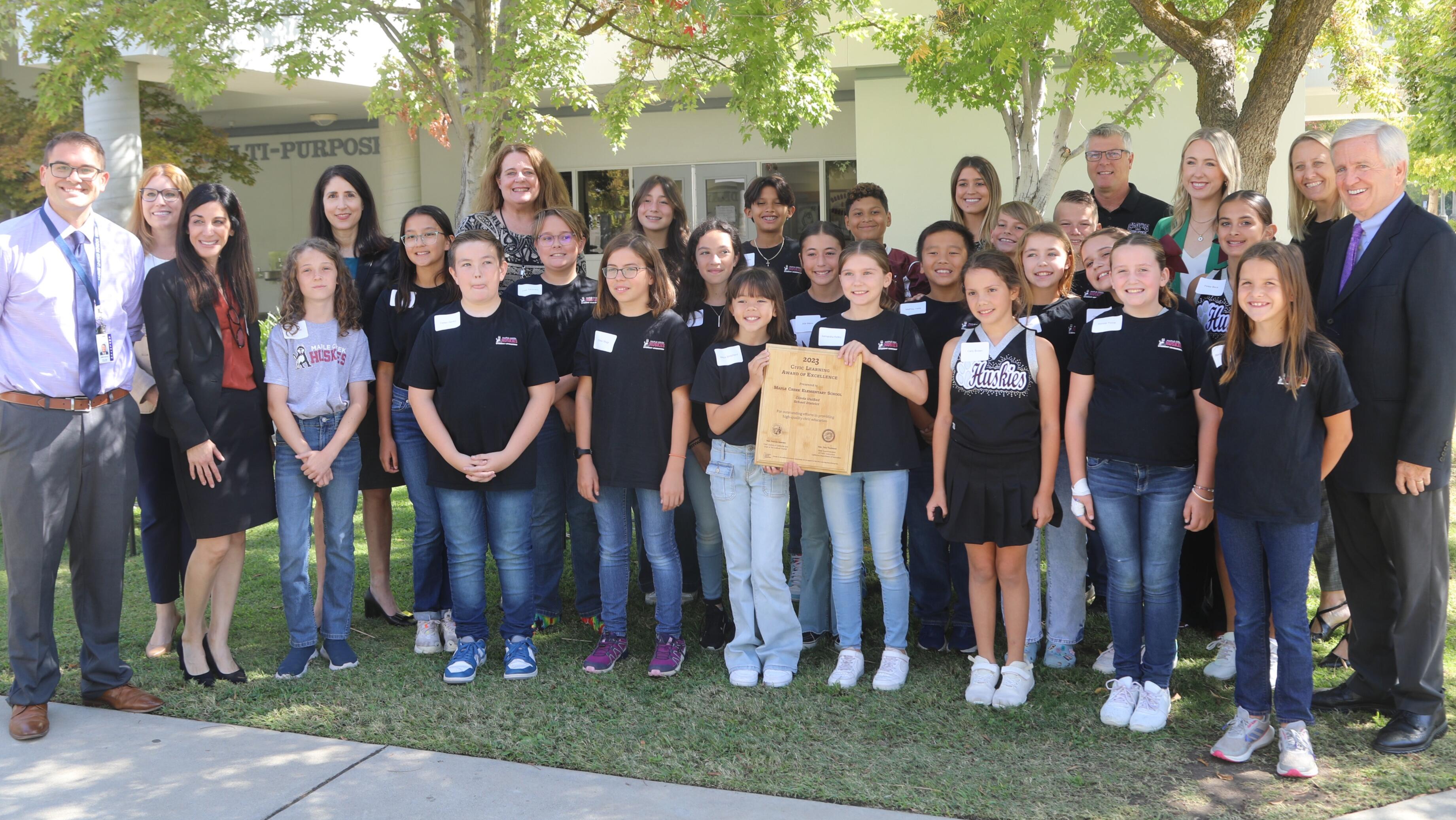 group of students standing outside with district reps and chief justice 