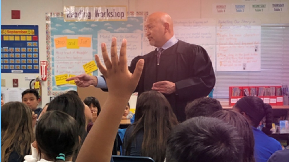 judge in classroom student hand raised