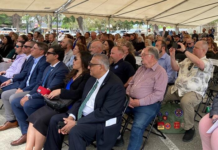 Hundreds of people sit in chairs under a tent at Willows Courthouse dedication ceremony