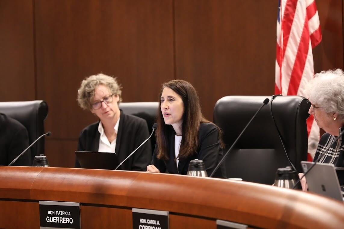 Three people sitting in a boardroom