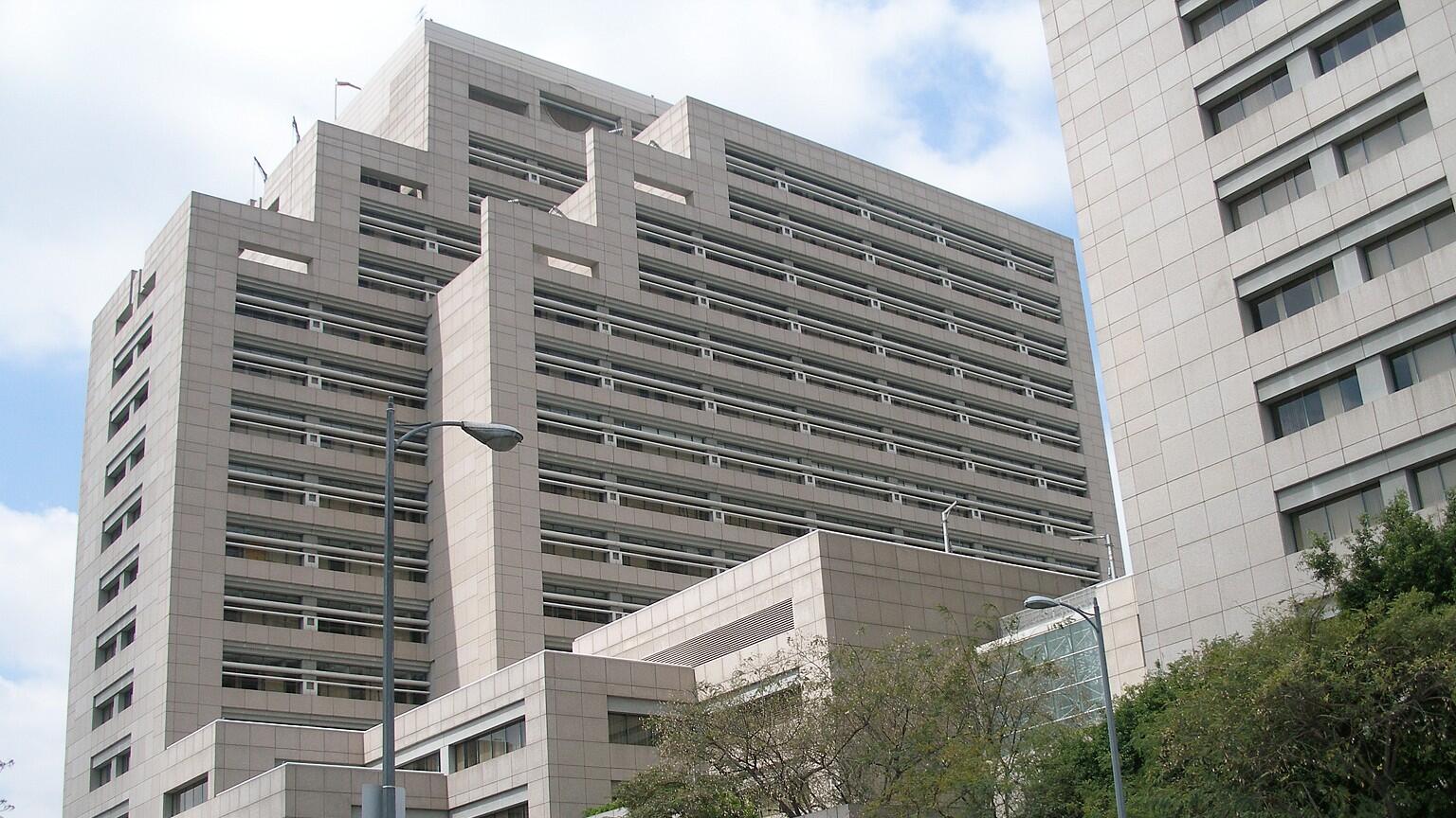 The Ronald Reagan State Building as viewed from the sidewalk, tall grey concrete towers with windows facing the street.
