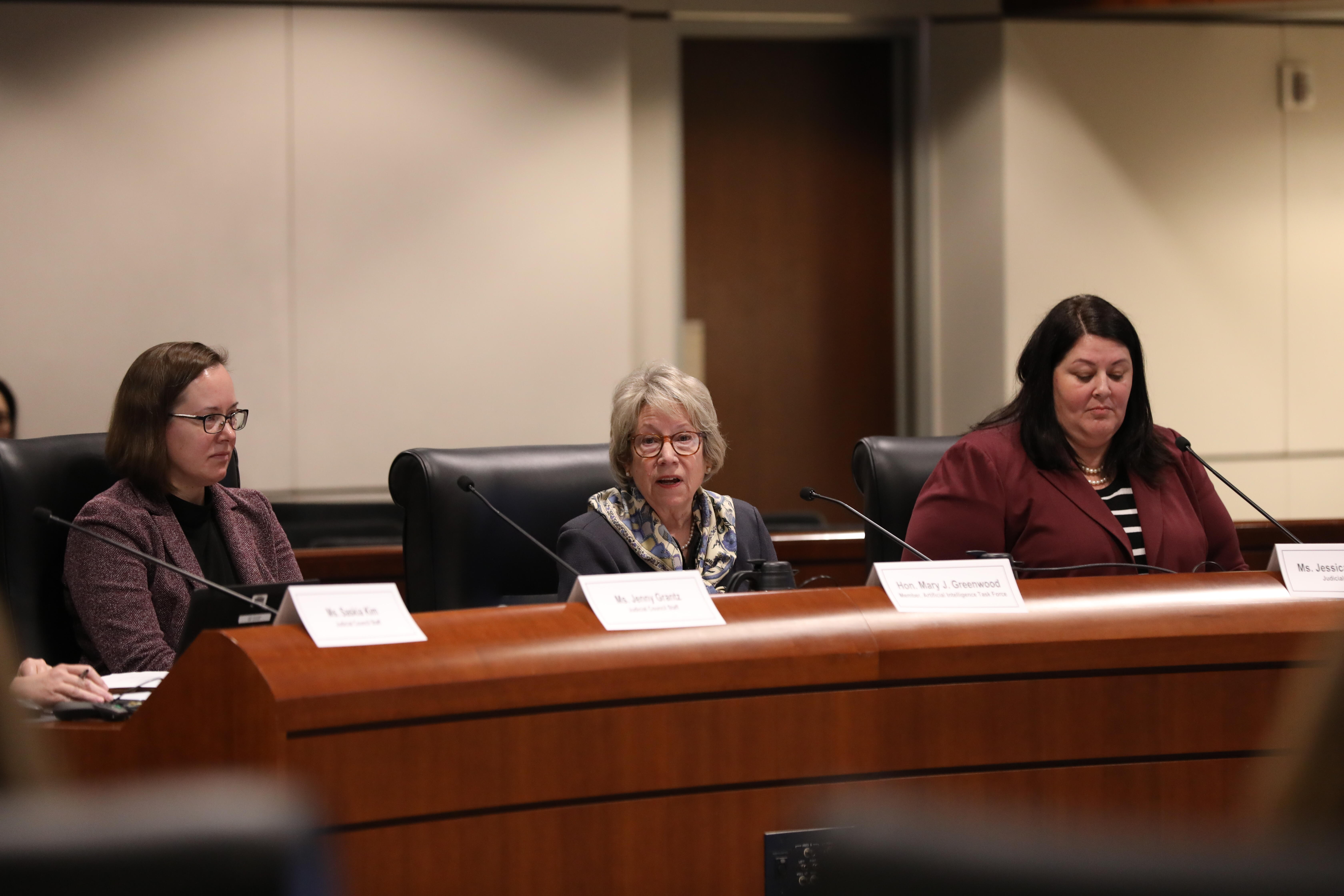 People sitting around a boardroom making a presentation to meeting attendees