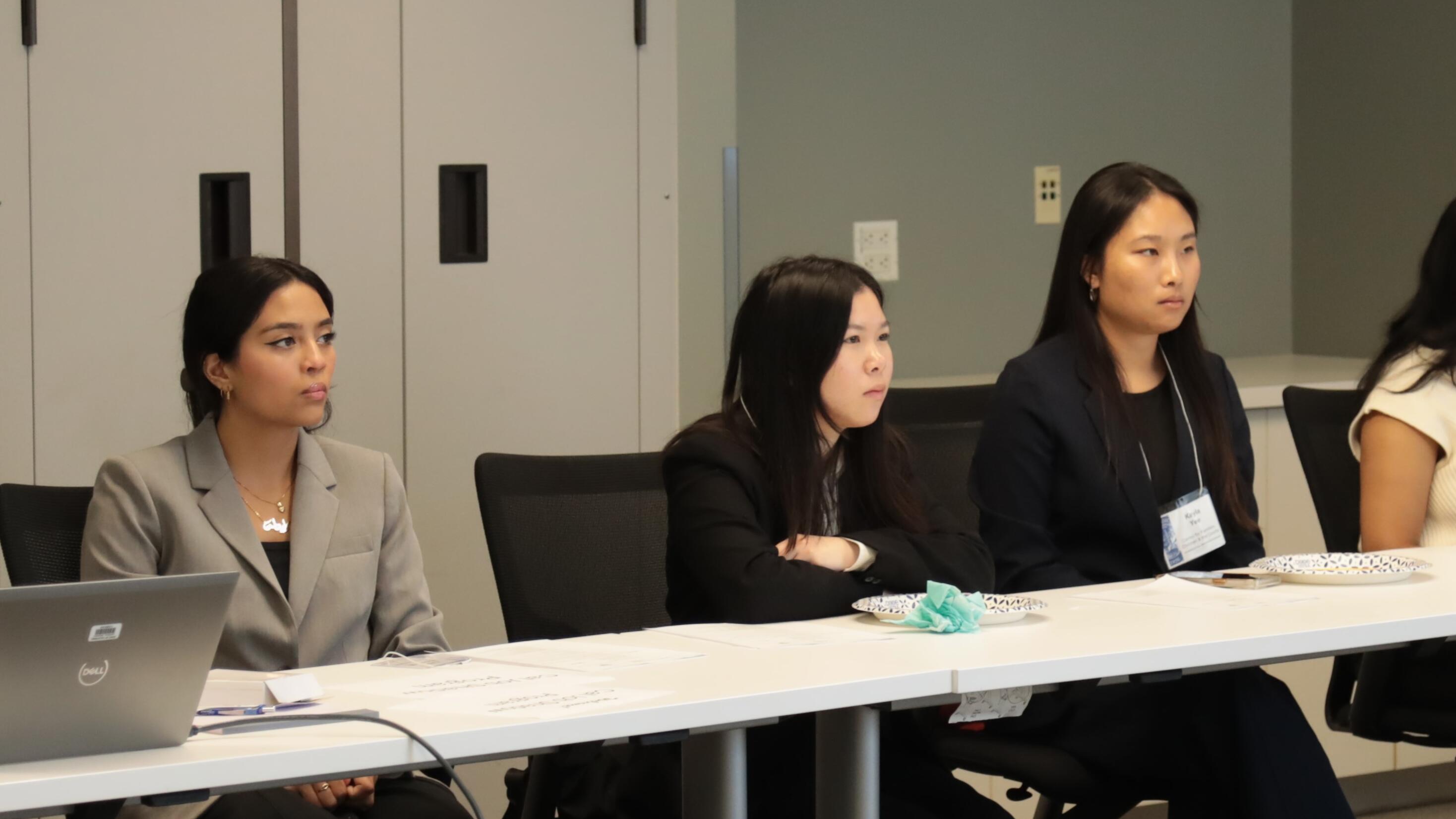 Students at long table listening to presentation