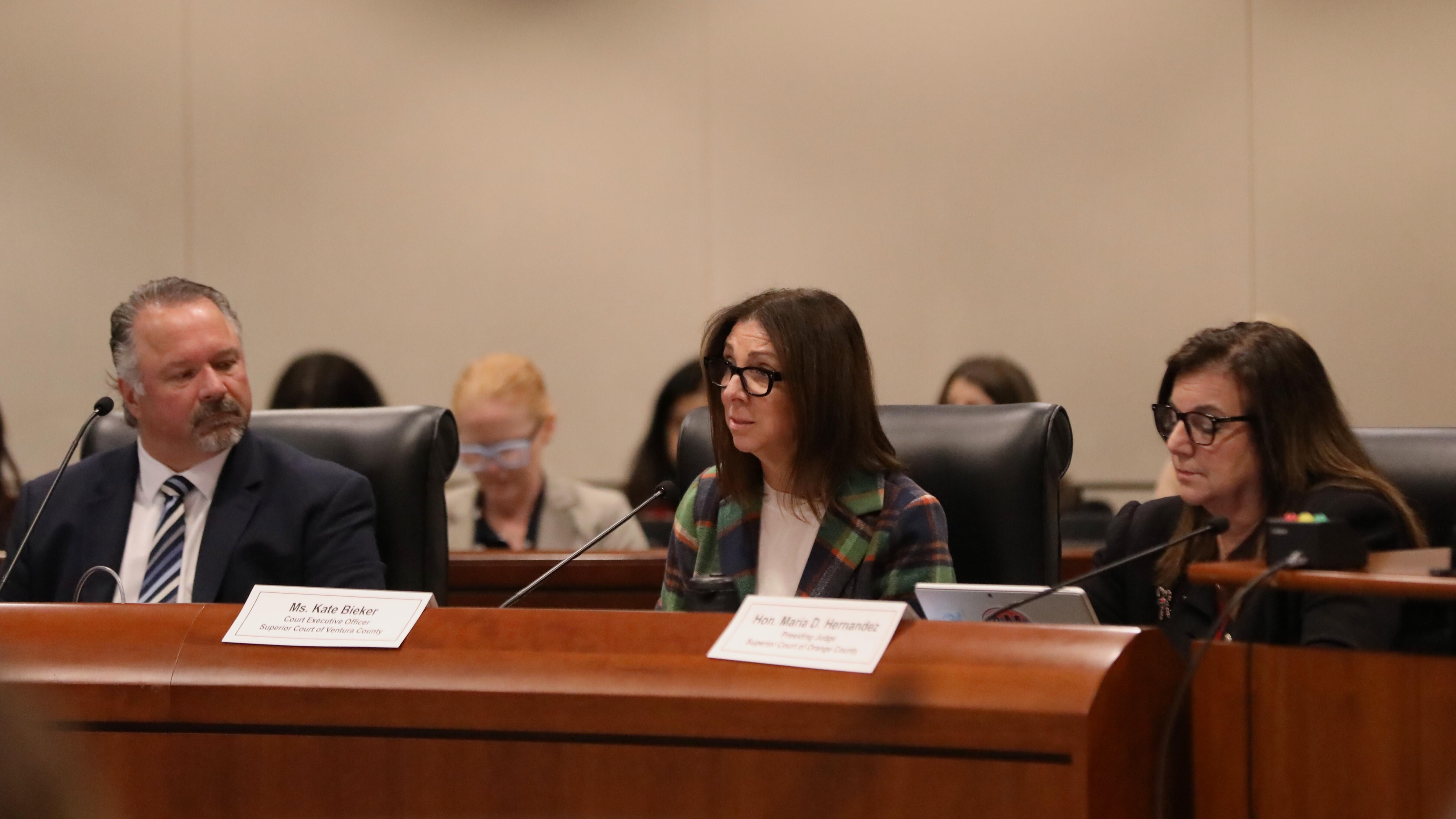 Three people sitting at a boardroom table