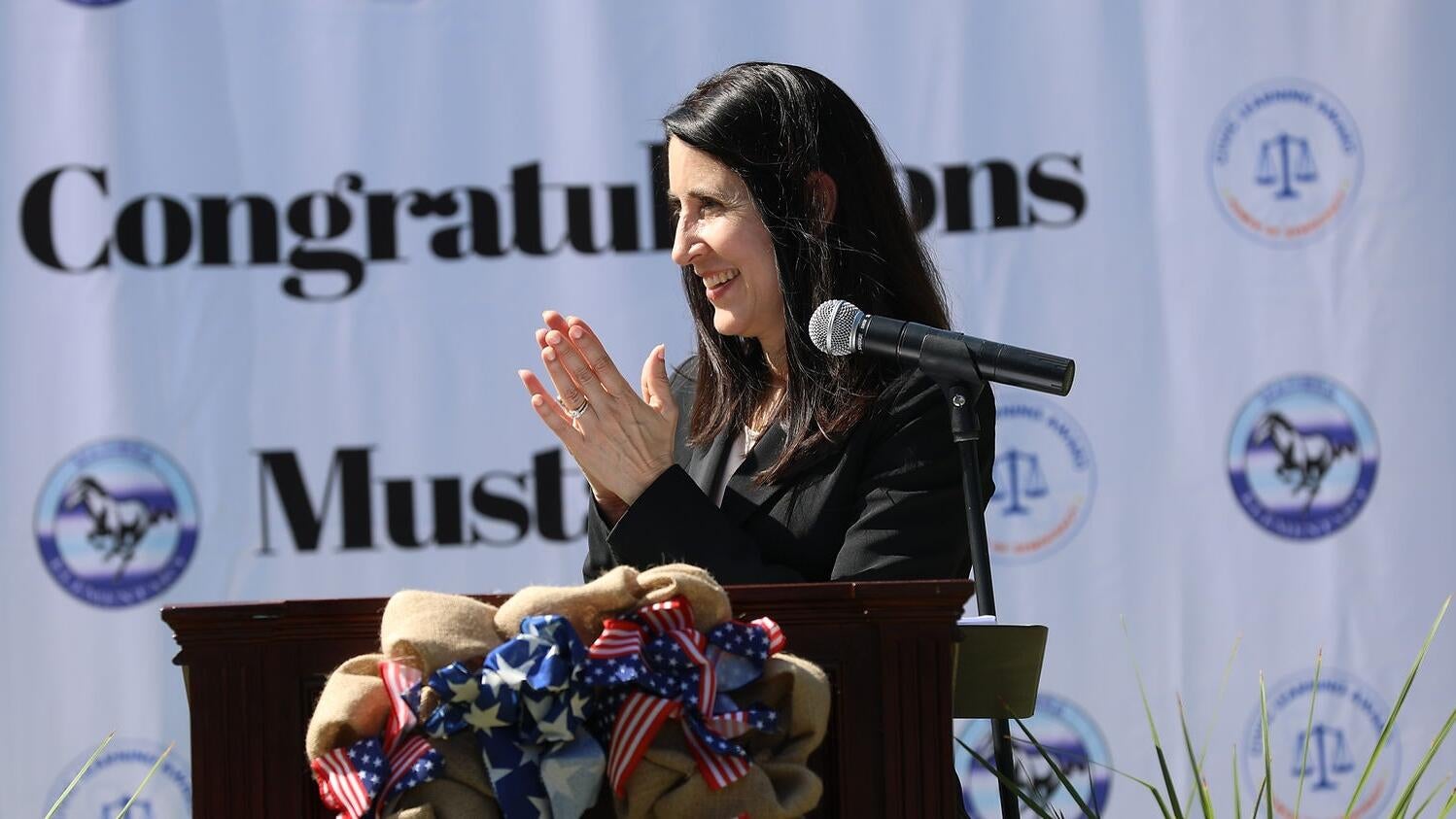 Chief Justice Patricia Guerrero stands at podium clapping.