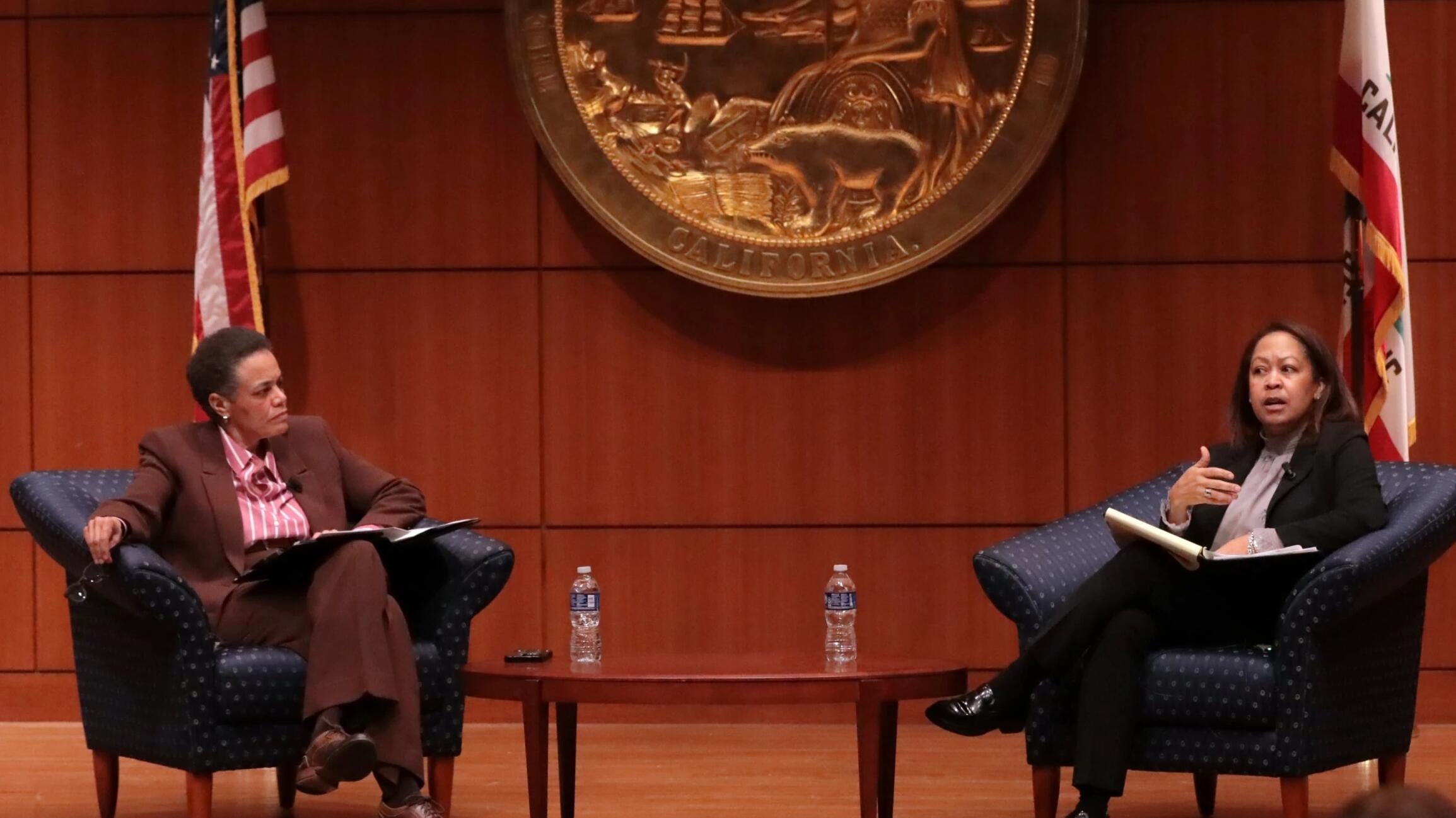 Two women sitting on stage