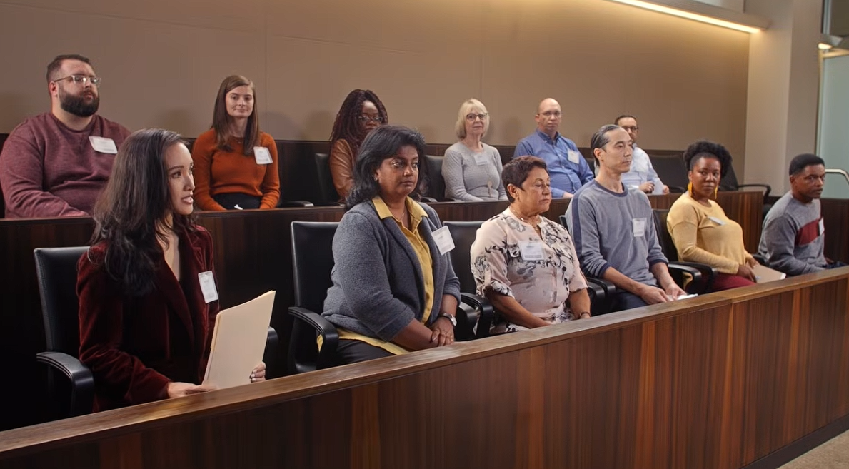 Jurors sit in a jury box inside a courtroom. 