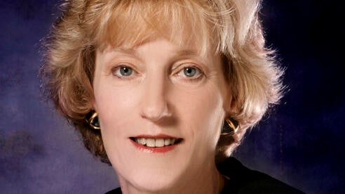 Woman in judicial attire faces camera.