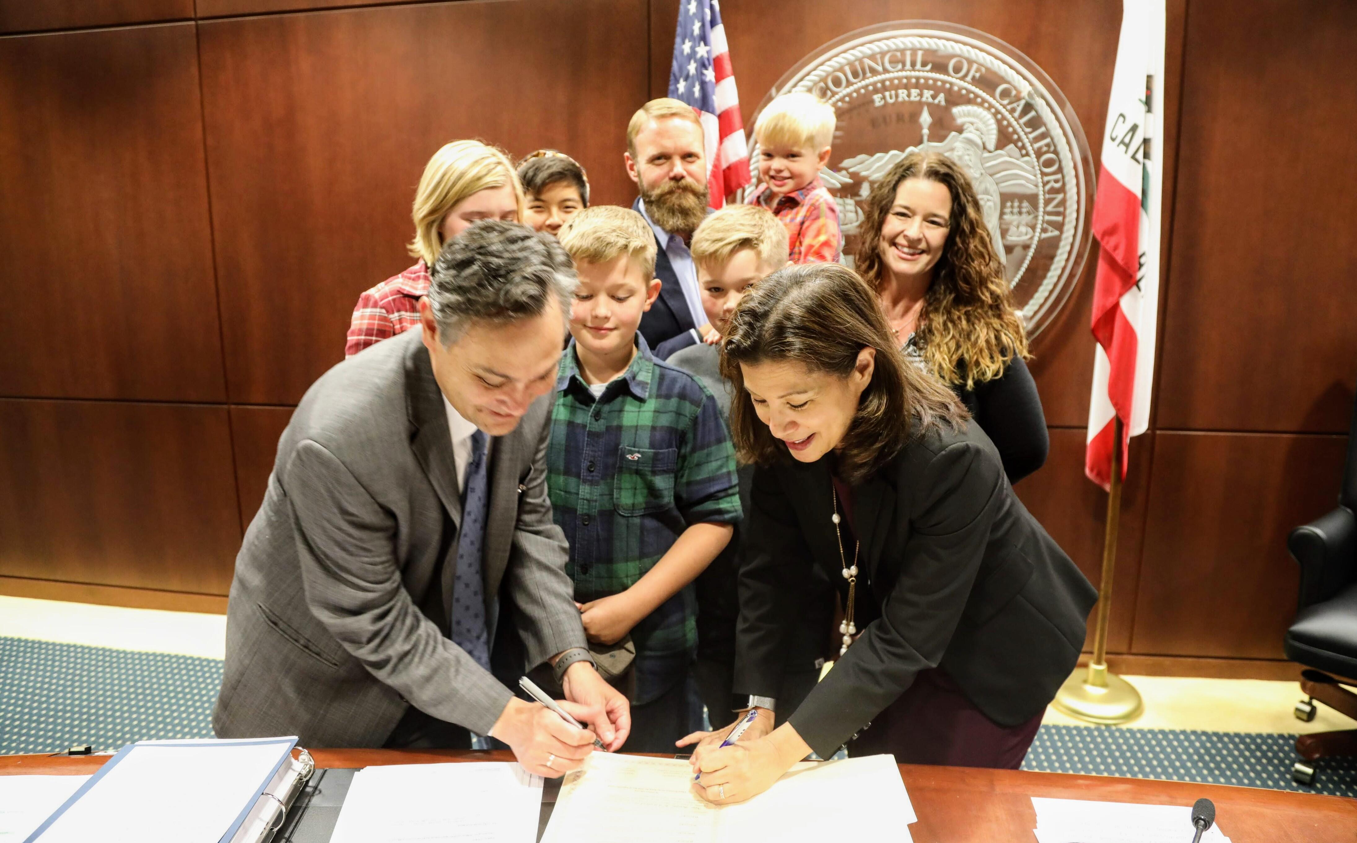 Chief Justice Tani Cantil-Sakauye and Administrative Director Martin Hoshino sign the resolution proclaiming November "Court Adoption and Permanency Month."