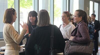Attendees at the statewide court technology summit talk in a hallway outside the main auditorium