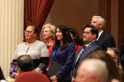 a group of people dressed in suits entering a large open room