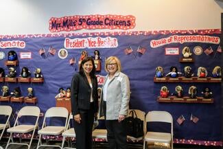 Chief justice and justice mcconnell standing in front of mural inside a classroom