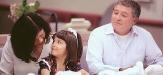 Parents sitting with child in courtroom during Adoption Day event in Superior Court of Los Angeles County