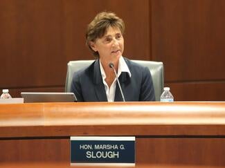 justice slough seated at council boardroom table