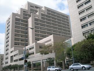 The Ronald Reagan State Building as viewed from the sidewalk, tall grey concrete towers with windows facing the street.
