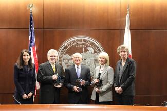 people posing in front of the Judicial Council seal