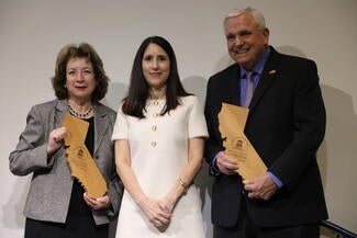 people on stage holding wooden award
