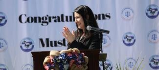 Chief Justice Patricia Guerrero stands at podium clapping.