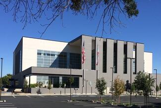 Sutter County Courthouse. A modern building with a facade of grey rectangular columns that connect to a square white building. 