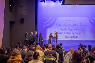 Justice presents plaque in an auditorium.